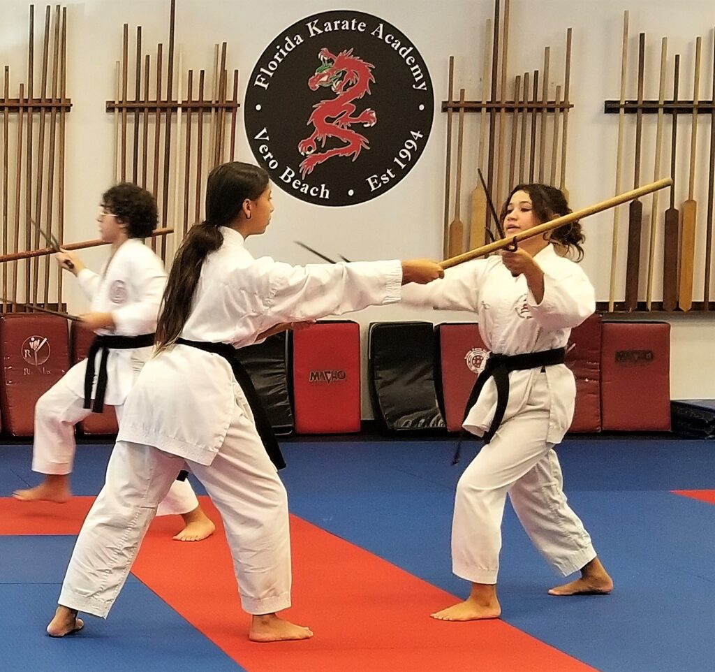 Karate students practicing with wooden sticks
