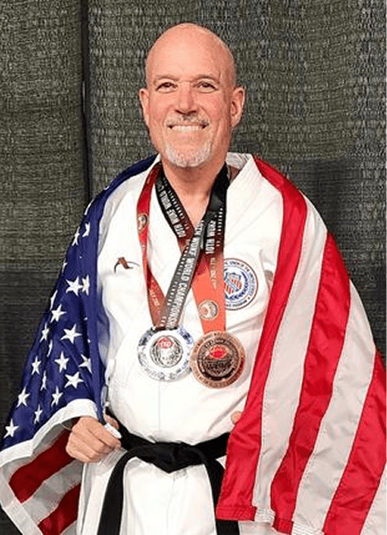 Black-belt with medals draped in American flag