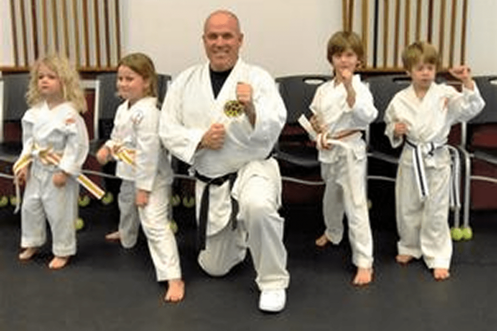 Karate class posing with belts