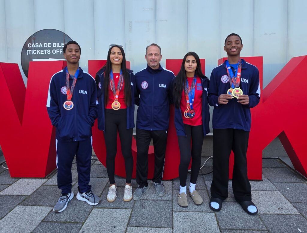 Florida Karate Academy athletes and coach wearing USA team uniforms and medals at the 2026 WUKF World Karate Championships in Cluj-Napoca, Romania
