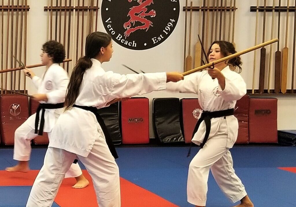 Karate students practicing with wooden sticks