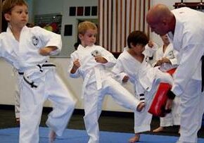 Children practicing martial arts kicks