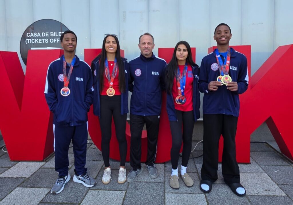 Florida Karate Academy athletes and coach wearing USA team uniforms and medals at the 2026 WUKF World Karate Championships in Cluj-Napoca, Romania
