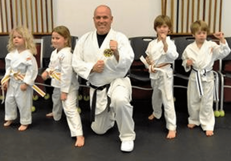 Karate class posing with belts